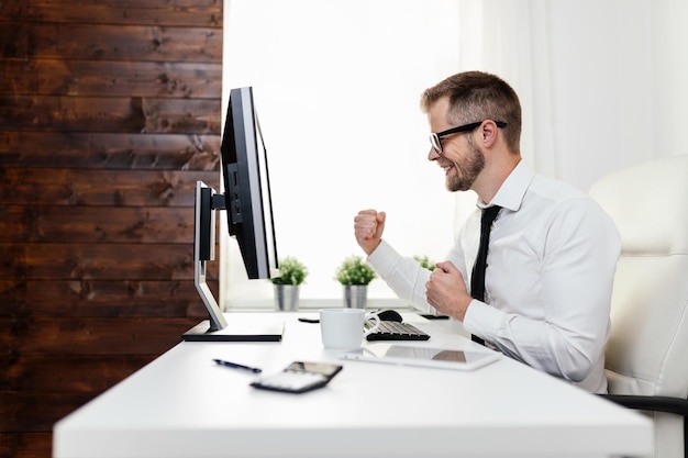 Erfolgreicher Geschäftsmann, der in seinem Büro sitzt
