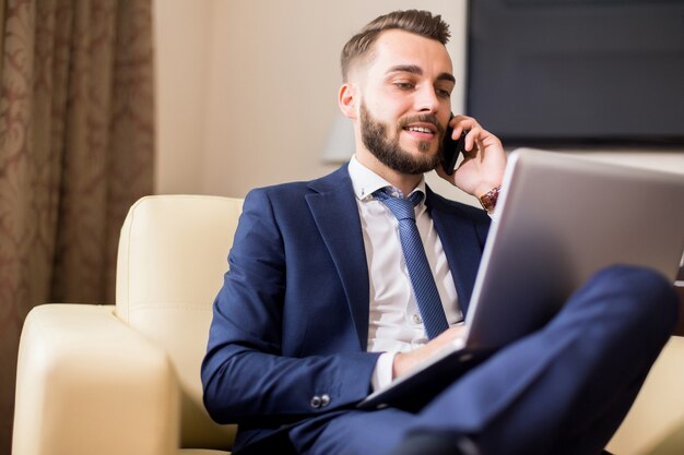 Erfolgreicher Geschäftsmann, der mit Laptop arbeitet