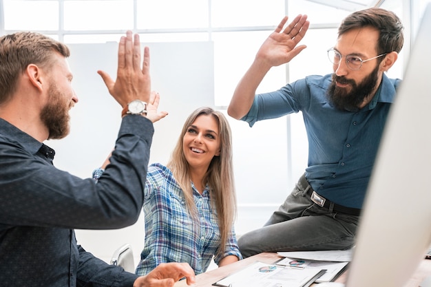 Erfolgreicher Geschäftsmann und seine Kollegen am Arbeitsplatz im Büro. das Konzept der Teamarbeit