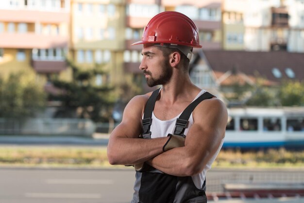 Erfolgreicher männlicher Architekt auf einer Baustelle mit gekreuzten Armen