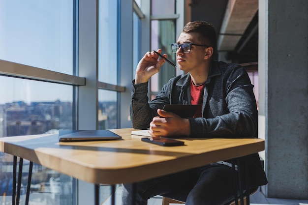 Foto erfolgreicher manager, der mit café-geschäftsinformationen, investitionsberichten arbeitet und notizen schreibt, während er online-recherchen auf laptop-computern durchführt, digitales marketing. arbeiten außerhalb des büros