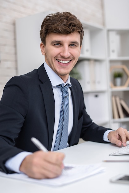 Erfolgreicher Unternehmer posiert am Arbeitsplatz