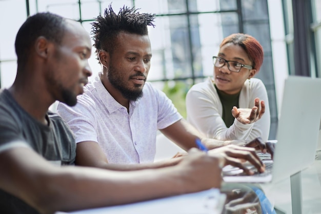 Erfolgreiches afroamerikanisches Geschäftsteam, das im Büro über Strategie spricht