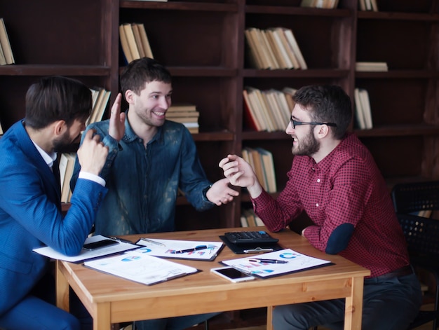 Erfolgreiches Geschäftsteam arbeitet mit den Finanzplänen am Arbeitsplatz im modernen Büro