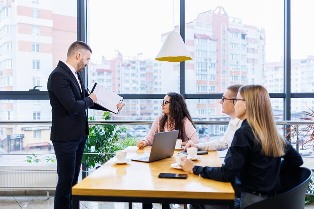 Erfolgreiches Treffen von Geschäftsleuten, Diskussion neuer Geschäftsideen, Verwendung von Diagrammen, Zusammensitzen. Moderner Bürohintergrund. Treffen von Geschäftspartnern bei der Konferenz zur Geschäftsentwicklung