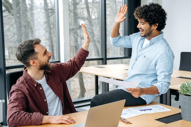 Erfolgskonzept erfolgreiche männliche Geschäftskollegen kreative Geschäftsleute arbeiten zusammen im Büro feiern Leistung Erfolgsabkommen geben fünf zueinander Lächeln