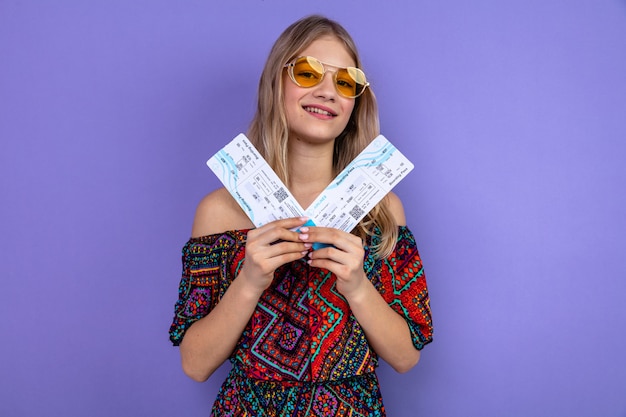 Foto erfreut junges blondes slawisches mädchen mit sonnenbrille mit flugtickets