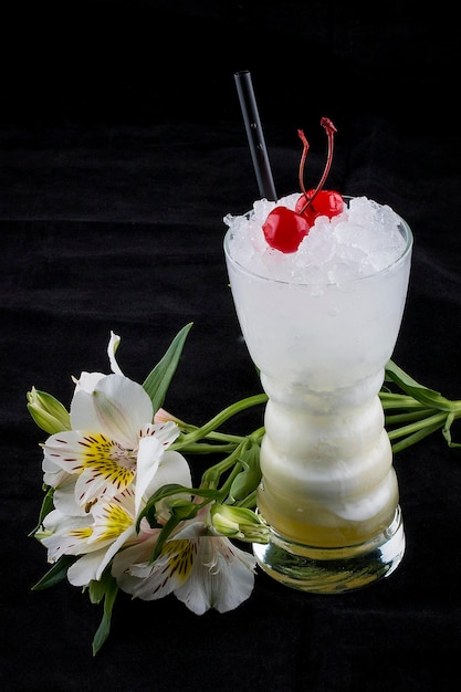 Erfrischender Cocktail in einem Glas auf schwarzem Hintergrund