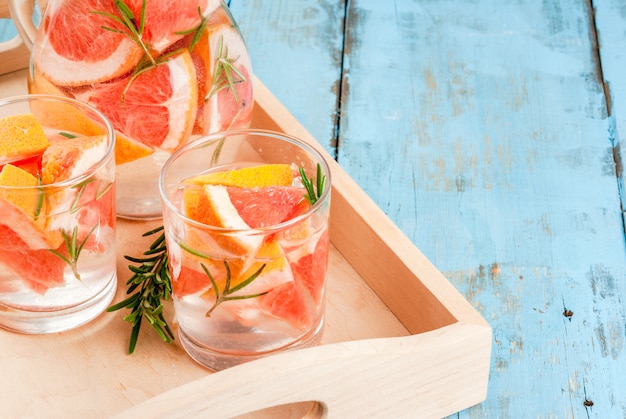 Erfrischender Sommer-Entgiftungscocktail aus Grapefruit und Rosmarin, auf rustikalem Holztisch, Kopierraum
