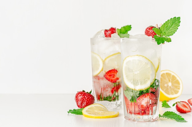 Erfrischender Sommercocktail mit Erdbeeren, Minze, Zitrone und Soda auf weißem Hintergrund. Speicherplatz kopieren