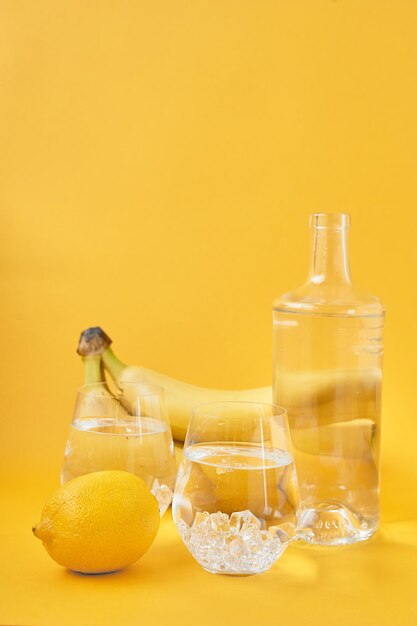 Erfrischendes Wasser mit Zitrone auf gelbem Hintergrund Gesunder LebensstilDurstlöschung