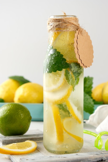 Erfrischungsgetränklimonade mit Zitronen, Minze, Kalk in einer Glasflasche