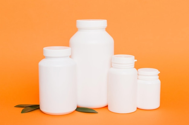 Ergänzungspillen mit Medikamentenflasche Gesundheitswesen und medizinische Draufsicht Vitamintabletten Draufsicht Mockup-Flasche für Pillen und Vitamine mit grünen Blättern natürlicher organischer Bio-Ergänzungskopierraum