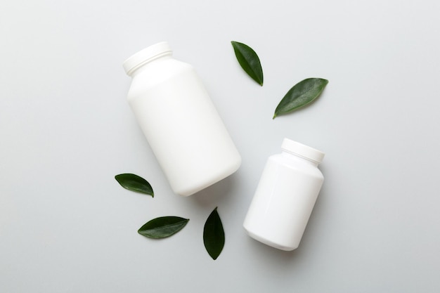 Ergänzungspillen mit Medikamentenflasche Gesundheitswesen und medizinische Draufsicht Vitamintabletten Draufsicht Mockup-Flasche für Pillen und Vitamine mit grünen Blättern natürlicher organischer Bio-Ergänzungskopierraum