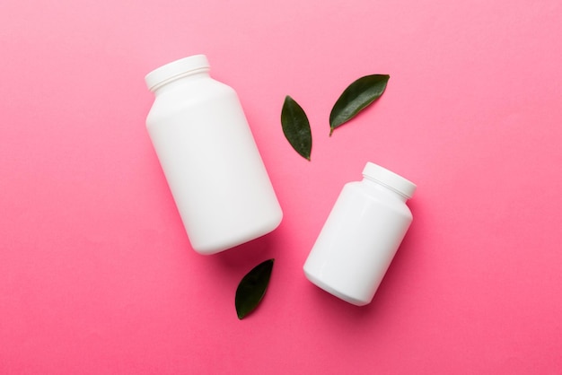 Ergänzungspillen mit Medikamentenflasche Gesundheitswesen und medizinische Draufsicht Vitamintabletten Draufsicht Mockup-Flasche für Pillen und Vitamine mit grünen Blättern natürlicher organischer Bio-Ergänzungskopierraum