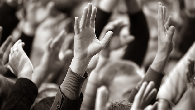 Foto erhob eine menschliche hand bei der veranstaltung. soziale herausforderungen und abstimmungen