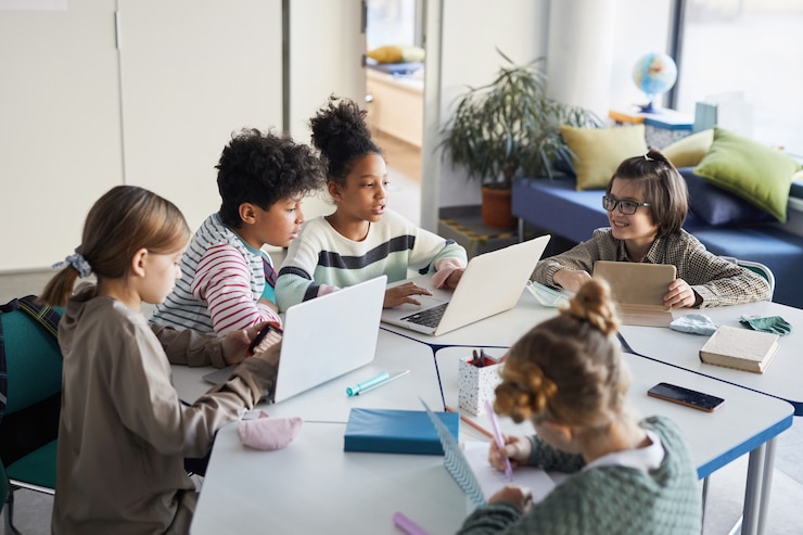 Foto erhöhte sicht auf eine gruppe von kindern am tisch in der modernen schule, kopierraum