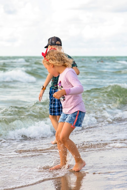 Erholung am Meer. Kinder stehen im heißen Sommer im Wasser am Strand. Kinder haben Spaß am Meer