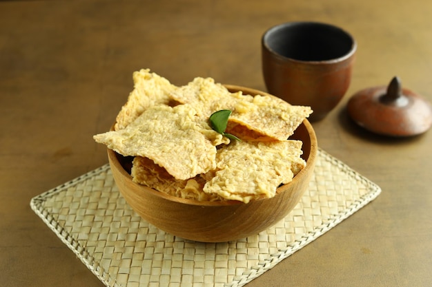 eripik tempe o chips de tempeh en un plato de madera Rebanadas de tempeh cubiertas con harina y fritas crujientes