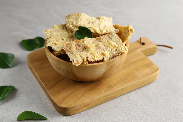 eripik tempe ou chips de tempeh na placa de madeira Fatias de tempeh revestidas com farinha e crocante frito