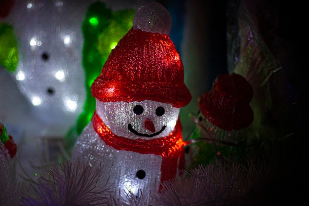 Foto erleuchteter schneemann und weihnachtsbaum zu hause