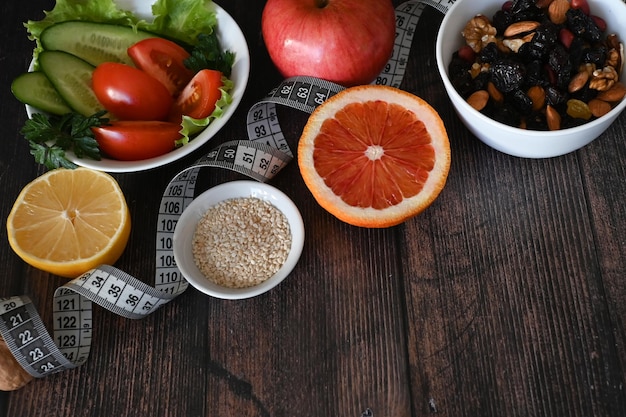 Ernährung Gesundheitsgemüse Früchte Zentimeterband auf dunklem Hintergrund