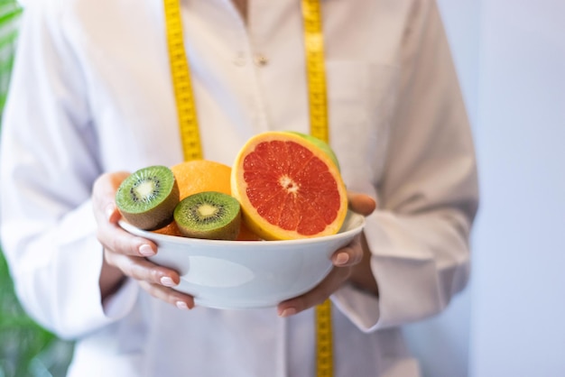 Ernährungsberater hält Schale mit gemischten Früchten