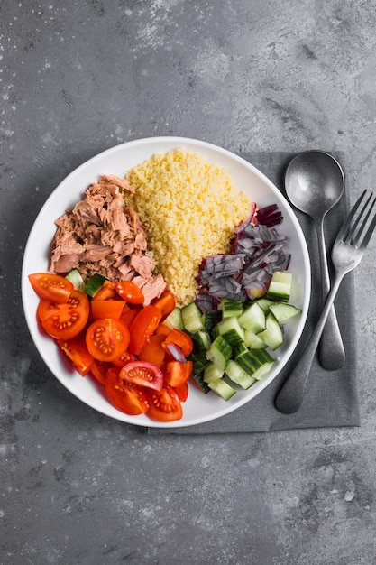 Ernährungskonzept Thunfischsalat Couscous-Salat mit konservierten Thunfisch-Tomaten-Gurken und violetten Zwiebeln auf dem Tisch Kopierbereich