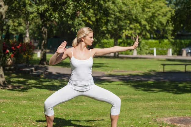 Ernste blonde Frau, die Yoga tut