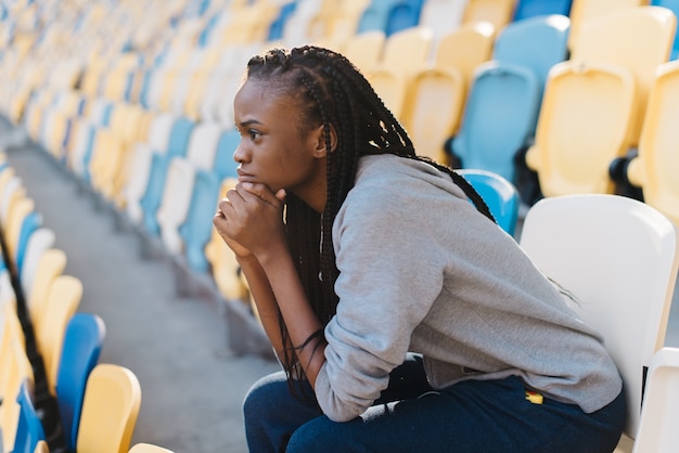 Ernste Frau auf einem Tribüne sitzen