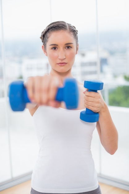 Ernster athletischer Brunette, der mit Dummköpfen trainiert