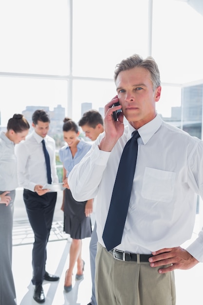 Ernster Chef am Telefon, das in einem modernen Büro steht