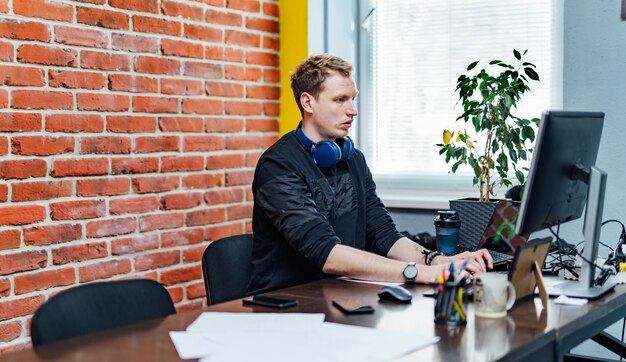 Ernster Geschäftsmann, der am Schreibtisch im Büro arbeitet