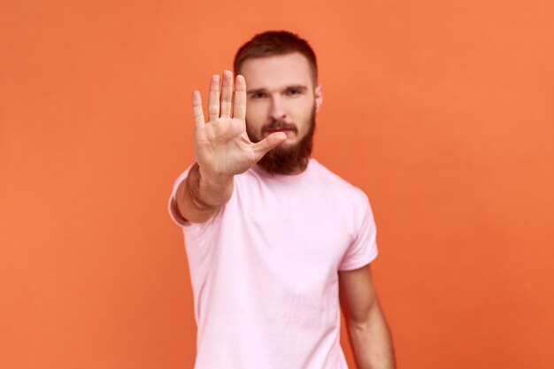 Ernster Mann, der eine Stoppgeste macht, die das Verbot von Handflächenkonflikten zeigt und vor Gefahren warnt