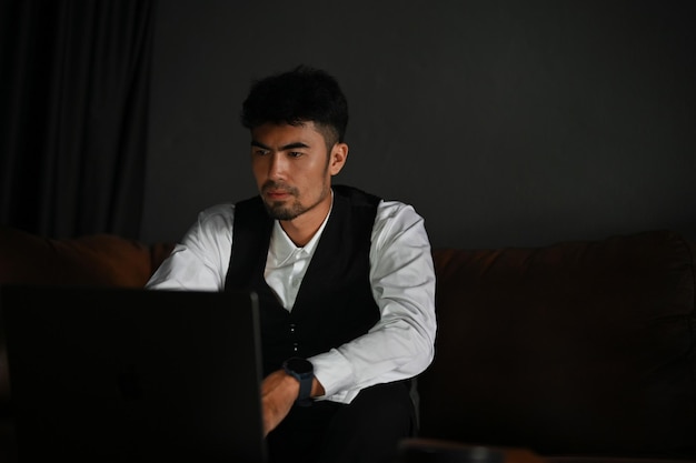 Ernster und professioneller asiatischer Geschäftsmann mit einem Notebook-Laptop-Computer