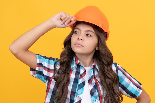 Ernstes Mädchen mit Schutzhelm. Kinderhelm zum Bauen. Schutz und Sicherheit. Kindererziehung. auf Baustelle. verbessern Sie Ihre Kindheit. zukünftiger Ingenieur. Arbeitstag. Reparaturen machen.