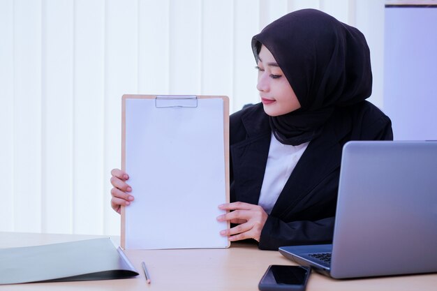 Ernsthaft geschäftliche junge Frau, die ein finanzielles Dokument im Büro hält