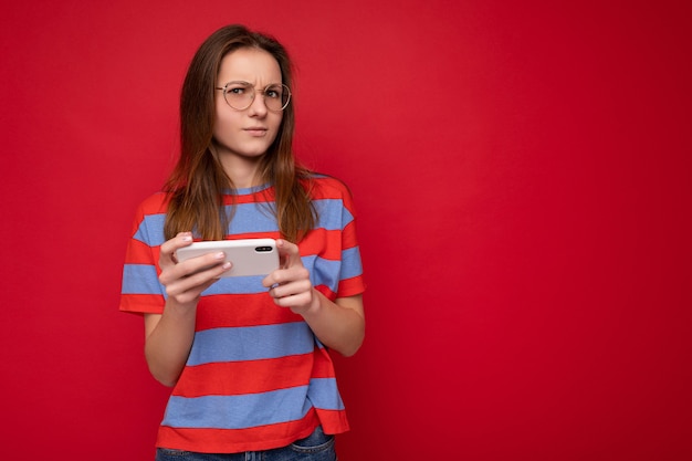 Ernsthafte attraktive, positiv gut aussehende junge Frau mit optischer Brille und lässigem Stil