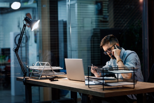 Ernsthafter Mann, der am Telefon im Büro spricht