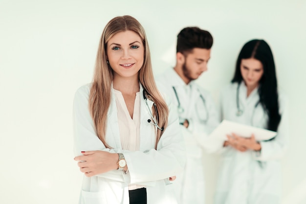 Ernsthafter Therapeut mit einer Zwischenablage im Stehen in der Klinik