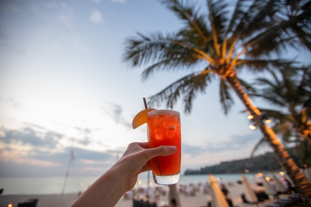 Ernte Hand mit Getränk am Strand