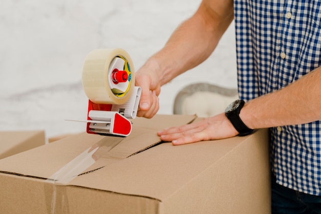 Foto ernte mann verpackung box mit klebeband