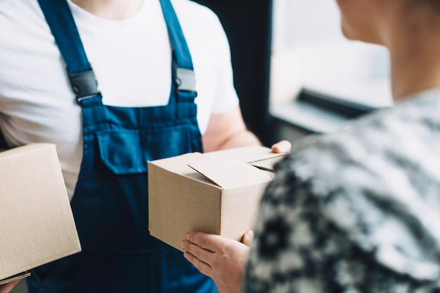 Foto erntefrau, die paket mit kurier empfängt