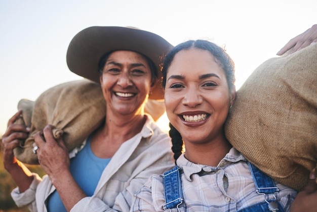 Foto erntefrauen auf dem bauernhof und glückliches porträt auf dem land mit einem lächeln bei der arbeit auf einer wiese mit getreidesack. nachhaltigkeit, umweltfreundlich und landwirtschaft im freien in der natur mit landwirtschaftlicher bewirtschaftung