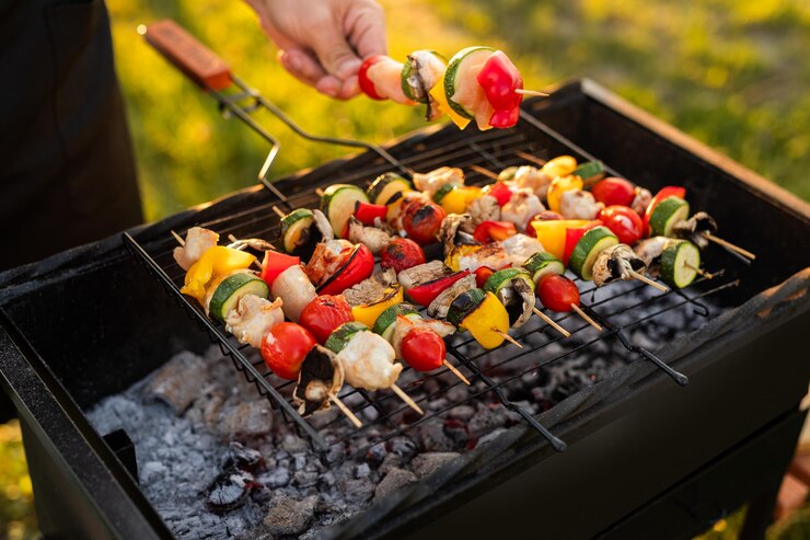 Erntemann, der Spieße auf dem Grill zubereitet