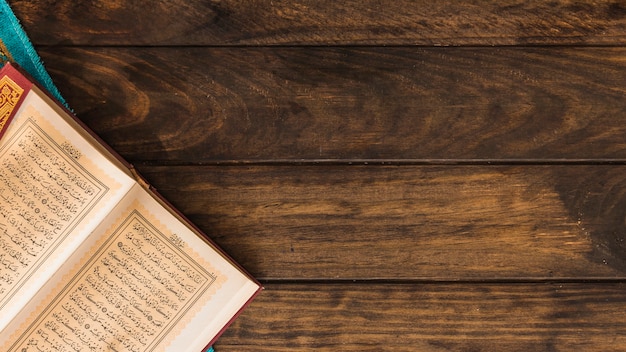 Eröffnete Koran und Lappen auf Holztisch