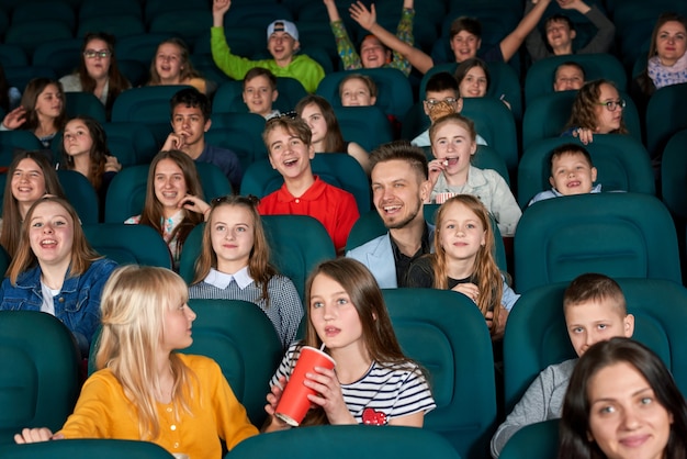 erregte Kinder, die im Kino sitzen.
