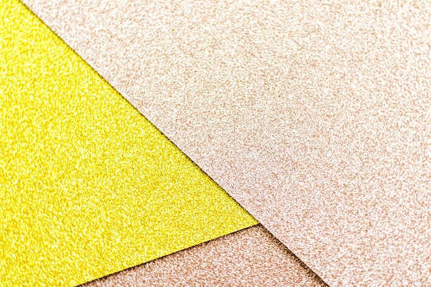 Erröten Sie rosa und gelbes glänzendes Glitterpapierhintergrundzusammenfassungs- und -feiertagshintergrund