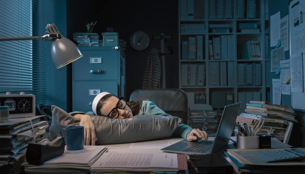 Erschöpfte Büroangestellte, die an ihrem Schreibtisch schläft