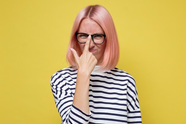 Erschöpftes tausendjähriges kaukasisches Mädchen, das eine unbequeme Brille trägt